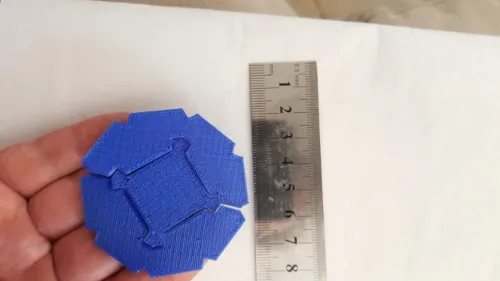 Blue printed still-life puzzle tiles held beside a ruler, photographed in June 2016.