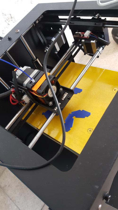 A second view of the blue tile pieces on the printer bed.